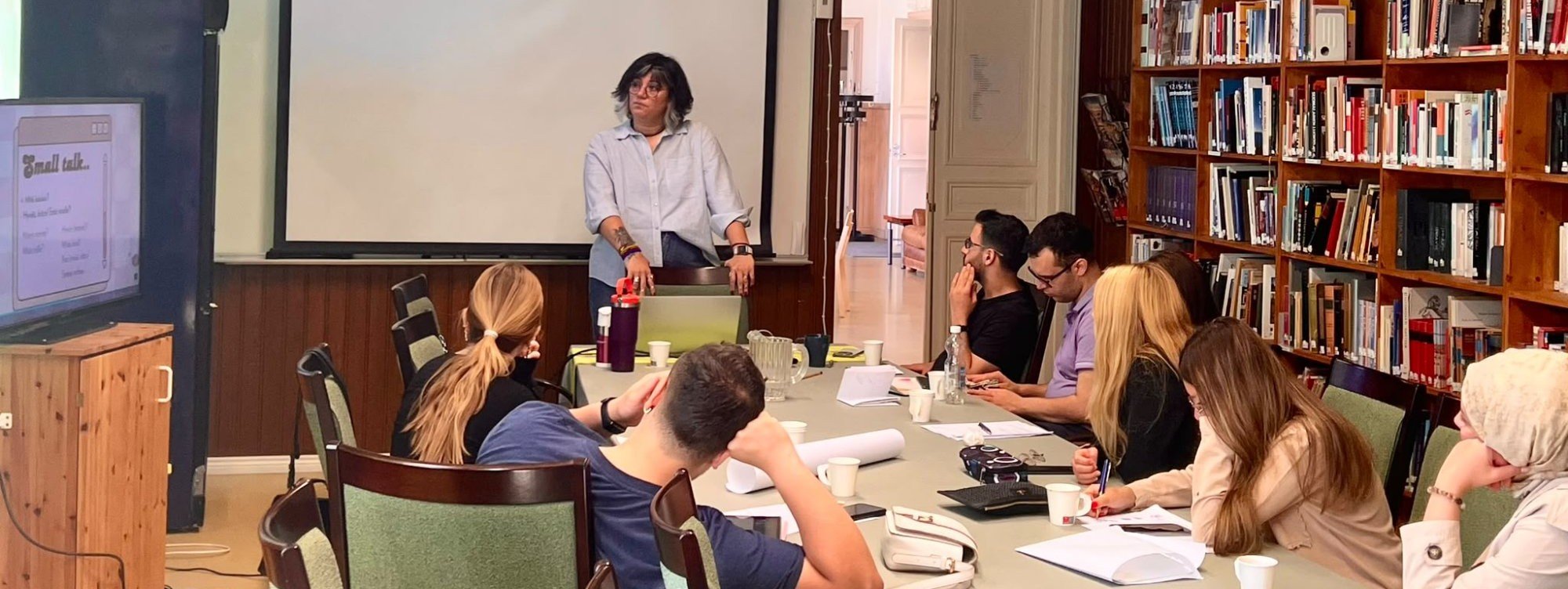 FinnsCool egitim semineri: egitmen sunum yaparken katilimcilar masada not aliyor.
